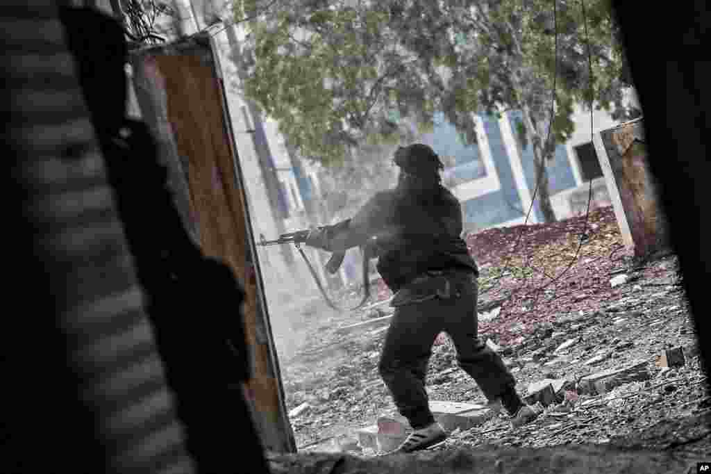 A Free Syrian Army fighter aims his weapon during heavy clashes with government forces in Aleppo, Syria, December 11, 2012.