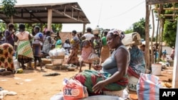 FILE - A vendor waits for customers to exchange her goods for other goods at the barter market in Togoville, Nov. 24, 2018. Every Saturday on the northern shore of Lake Togo, some 65 kilometers (40 miles) east of the capital, Lome, Togoville runs a lively barter market.