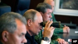 Президент РФ Владимир Путина наблюдает за военными учениями на Лужском полигоне. Архивное фото