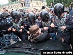 RUSSIA -- Russian police officers push a teenager during a rally protesting retirement age hikes in St. Petersburg, September 9, 2018