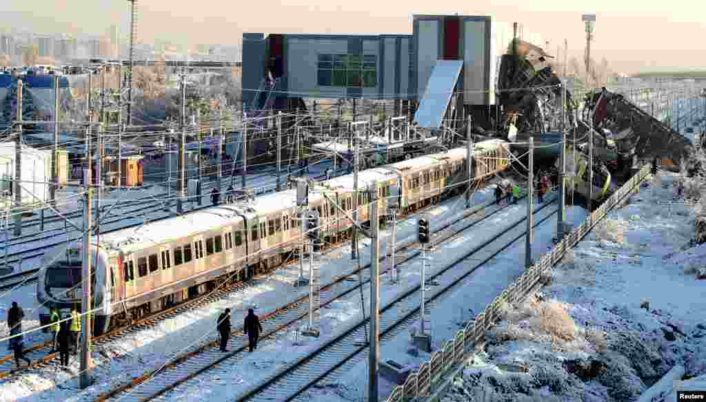 Rescue workers search the wreckage after a high-speed train crash in Ankara, Turkey. Nine people were killed and nearly 50 were injured when a high-speed train struck a locomotive and crashed into a raised station area and overpass, officials said.