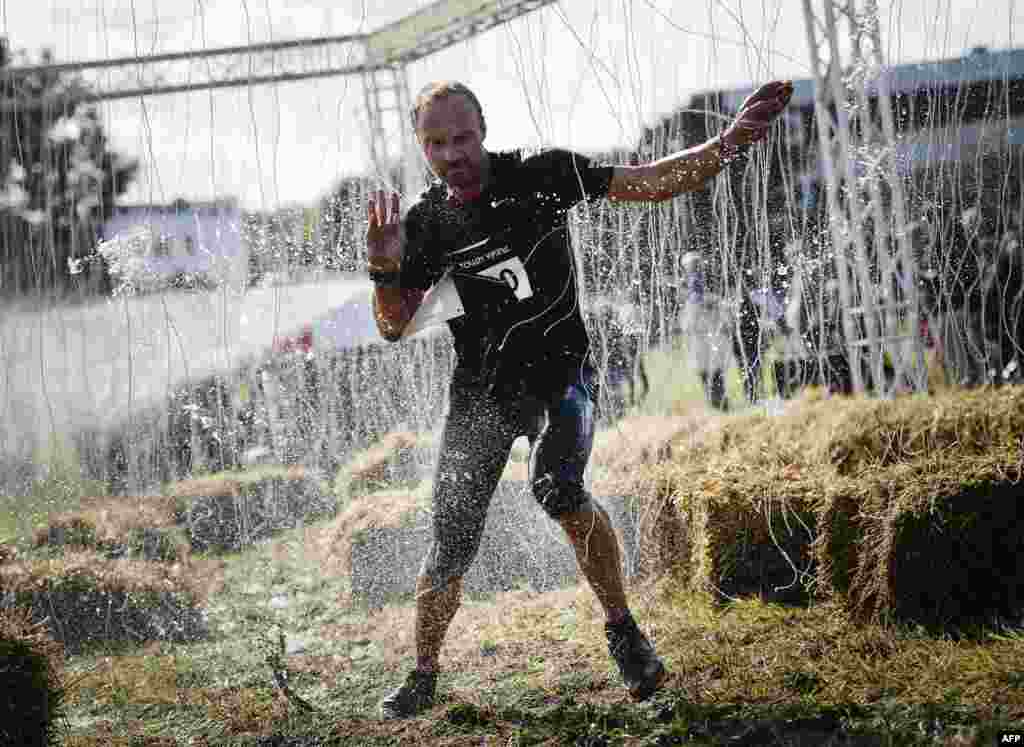 A man reacts as he completes the 10000 Volt obstacle consists of 12 kilometers filled with 15 brutal obstacles (barbed wire, mud, ice, water, tunnels, electricity, fire, climbing, etc.) part of the Tough Viking race in Stockholm, Sweden, Sept. 1, 2013.
