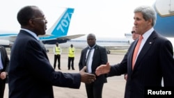 U.S. Secretary of State John Kerry (R) shakes hands with Democratic Republic of Congo Foreign Minister Raymond Tshibanda upon his arrival at N'djili Airport in Kinshasa, May 3, 2014. 