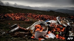 FILE - Wrecked boats and thousands of life jackets used by refugees and migrants during their journey across the Aegean sea lie in a dump in Mithimna, Greece, Feb. 19, 2016. 