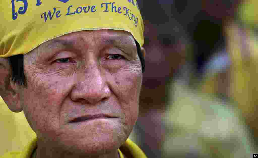 An elderly man listens to King Bhumibol Adulyadej make a speech on a giant screen, on the king's 86th birthday at the Democracy Monument in Bangkok, Dec. 5, 2013.