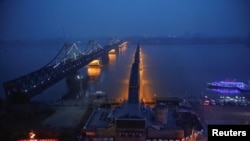 Lights are turned on on the Friendship and the Broken bridges over the Yalu River connecting the North Korean town of Sinuiju and Dandong in China's Liaoning province, March 30, 2017.