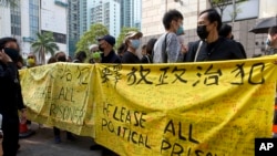 資料照：香港民眾舉著橫幅在法庭外，為在新國安法下被拘留的47名活動人士表示支持。 （美聯社2021年3月1日拍攝)