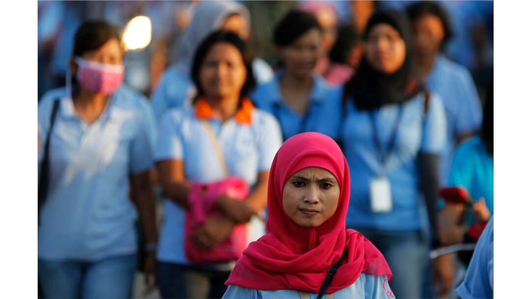 Seorang pekerja pabrik sepatu pulang kerja setelah pulang kerja, di kawasan industri Pasar Kemis di Tangerang, 13 Agustus 2014. (Foto: Reuters)