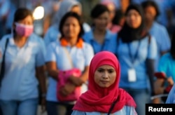 Seorang pekerja pabrik sepatu berjalan pulang setelah bekerja, di kawasan industri Pasar Kemis di Tangerang 13 Agustus 2014. (Foto: Reuters)