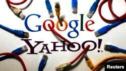 An illustration shows the logos of Google and Yahoo connected with LAN cables in a Berlin office Oct. 31, 2013. 