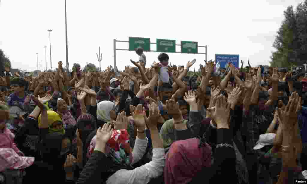 Migrants shout slogans as they stand in front of a barrier at the border with Hungary near the village of Horgos, Serbia, Sept. 16, 2015. Hungary's right-wing government shut the main land route for migrants into the European Union, taking matters into its own hands to halt Europe's influx of refugees.