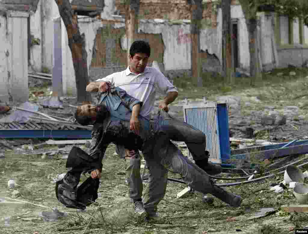 A wounded Afghan police officer is carried away from the site of an explosion in Kabul, May 24, 2013.