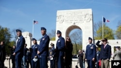 US Air Force soldiers watch an aerial parade during a ceremony honoring the lives of the American pilots who volunteered to fight for France during World War I, in Marne la Coquette, outside Paris, Wednesday, April 20, 2016. 