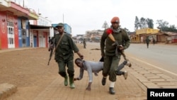 Congolese soldiers drag away a protester critical of the government's alleged inaction to address rising inter-ethnic tensions in the town of Butembo, in North Kivu province, DRC, Aug. 24, 2016.