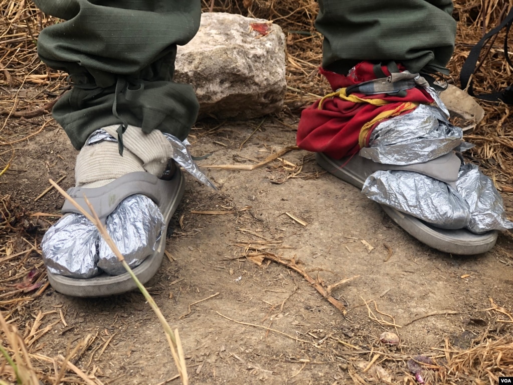 Juan Rosales un venezolano que caminó hasta la frontera entre Colombia y Ecuador, usa lo que puede para calentarse los pies, tras quedarse sin zapatos en su travesÃa. Ipiales, Colombia, 11 de septiembre de 2019. Foto: Celia Mendoza - VOA.