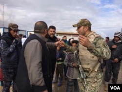 Soldiers explain security procedures intended to catch any militants trying to flee with families as they arrive at camps outside of Mosul on March 19, 2017 in Hammam Aleel, Iraq. (H.Murdock/VOA)