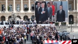 FILE - President Donald Trump and French President Emmanuel Macron during Bastille Day parade on the Champs Elysees avenue in Paris, July 14, 2017. 