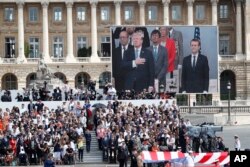 FILE - President Donald Trump and French President Emmanuel Macron during Bastille Day parade on the Champs Elysees avenue in Paris, July 14, 2017.