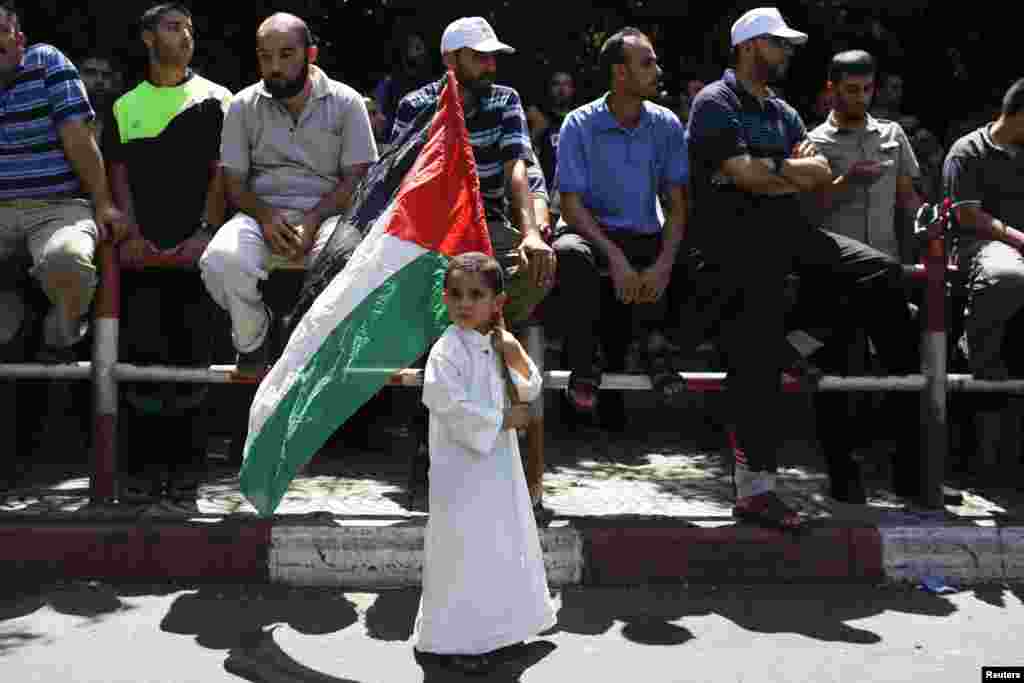 A boy holds a Palestinian flag in support of Hamas during a rally while mediators work against the clock to extend a truce between Israel and the Palestinians, as the three-day ceasefire went into its final 24 hours, in Gaza City Aug. 7, 2014.