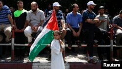 Seorang bocah membawa bendera Palestina dalam sebuah demonstrasi mendukung Hamas di Gaza City bulan lalu.