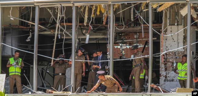 Un policía de Sri Lanka inspecciona el lugar de una explosión en el hotel Shangri-la en Colombo, el domingo 21 de abril de 2019.