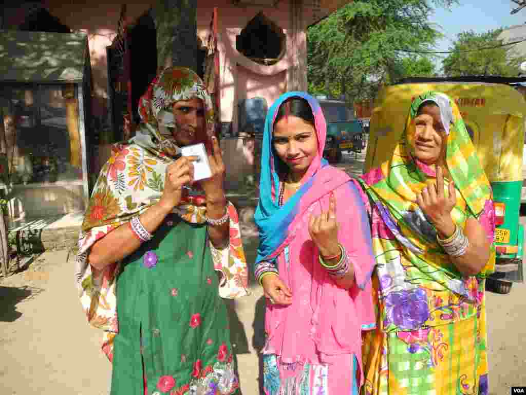 Residents of a low income settlement in Gurgaon, adjoining New Delhi, hold up their fingers after voting, April 10, 2014. (Anjana Pasricha/VOA)