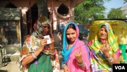 Residents of a low income settlement in Gurgaon, adjoining Delhi, hold up their fingers after voting, April 10, 2014. (Anjana Pasricha/VOA)