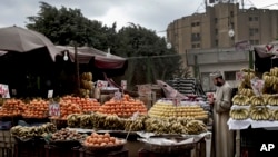 A fruit vendor checks an apple as he waits for customers in the Sayeda Zeinab neighborhood of Cairo, Egypt. Egyptians are cutting spending and trying to make it through the country’s worst inflation in a decade under President Abdel-Fattah el-Sissi’s economic reforms.
