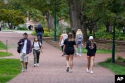 FILE - Students walk to and from classes on the Indiana University campus on October 14, 2021 in Bloomington, Indiana.  (AP Photo/Darron Cummings)