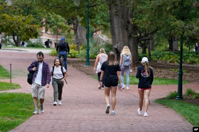 FILE - Students walk to and from classes on the Indiana University campus, Oct. 14, 2021, in Bloomington, Indiana. (AP Photo/Darron Cummings)