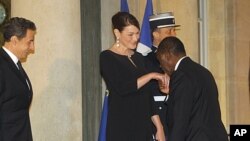 France's President Nicolas Sarkozy, left, and Carla Bruni-Sarkozy welcome Ivory Coast President Alassane Ouattara as he arrives for a state dinner at the Elysee Palace in Paris, January 26, 2012.