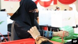 Bahraini women cast their ballots at a polling station in Manama, 24 October 2010