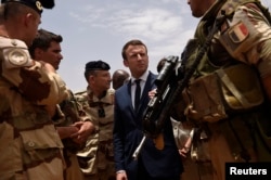 FILE - French President Emmanuel Macron visits French troops in Africa's Sahel region in Gao, northern Mali, May 19, 2017.