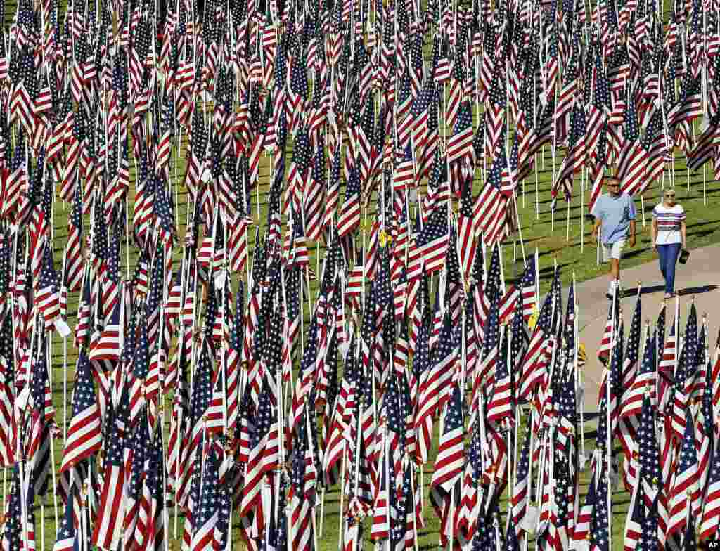 A couple walks through the &quot;Healing Field&quot; at Tempe Beach Park in Tempe, Arizona, USA, on the 12th anniversary of the 9/11 terrorist attacks. The display has nearly 3,000 flags with the names of those who died in the attacks.