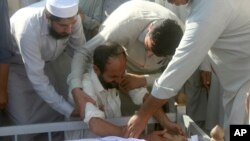 Villagers comfort a family member of Haroon Khan, a journalist killed the previous day in Swabi, Pakistan, Oct. 13, 2017. 
