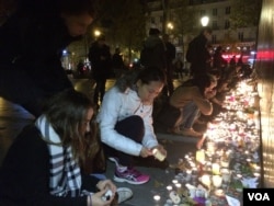 FILE - People pay homage to terror attack victims at the Place de la Republique square in Paris, France after panic spread about another possible attack, Nov. 15, 2015. (Photo: D. Schearf / VOA)