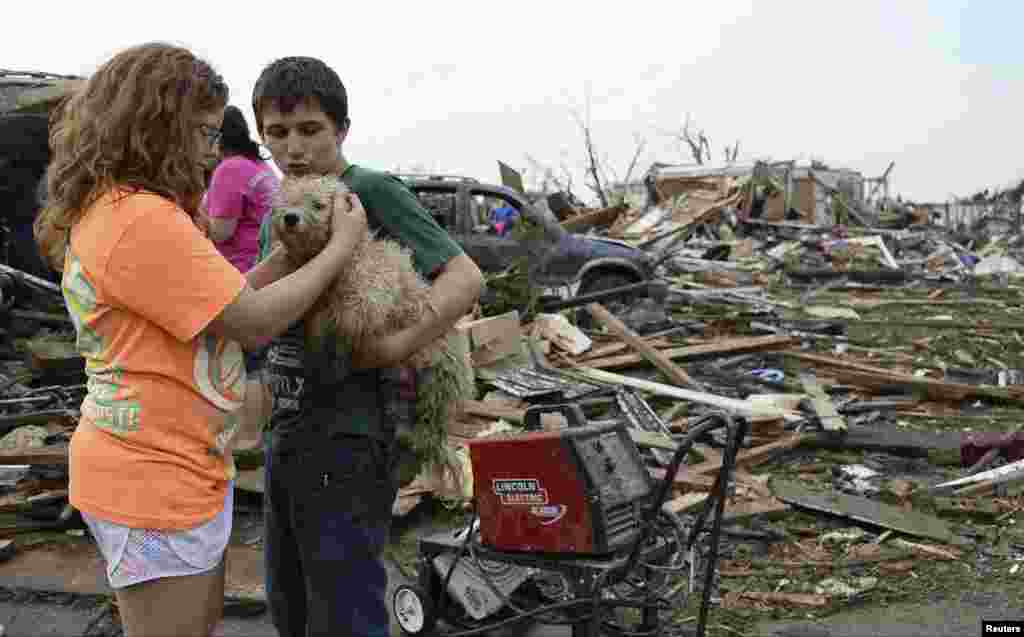 Abby Madi, izquierda y Peterson Zatterlee acarician a la mascota de&nbsp; Zaterlee, un perrito de nombre Rippy despu&eacute;s del tornado que sacudi&oacute; Moore en Oklahoma.