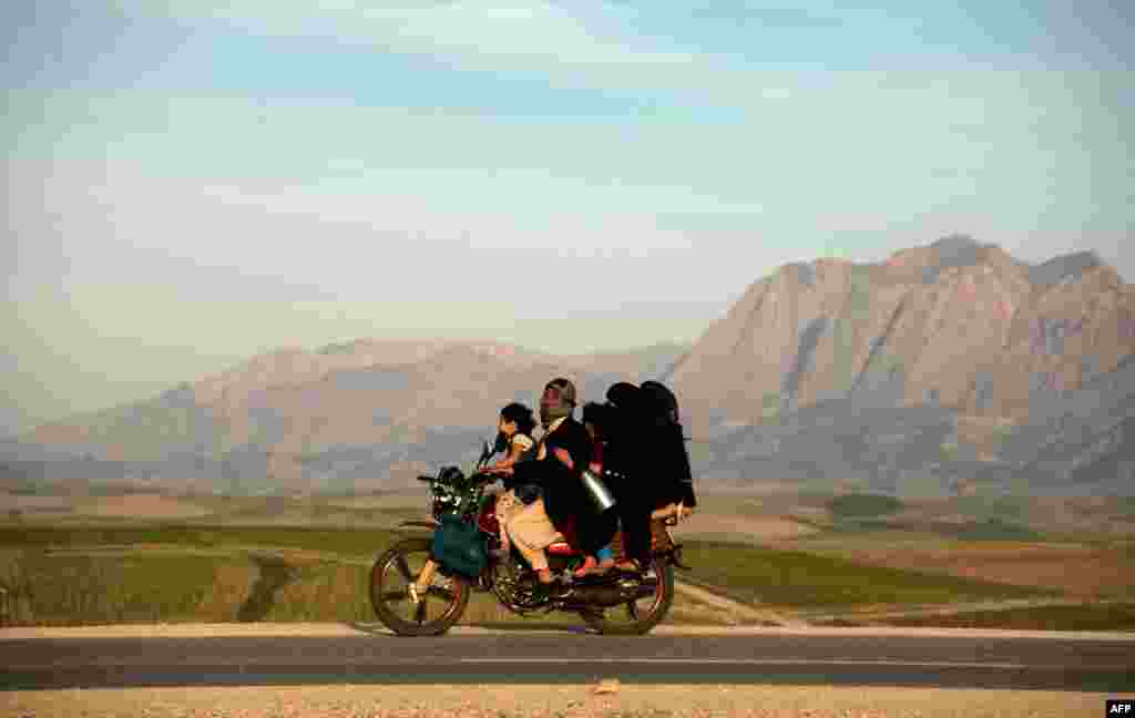 An Afghan family travels on a motorcycle to celebrate Nowruz, which marks the Central Asian New Year, on the outskirts of Mazari-i-Sharif.