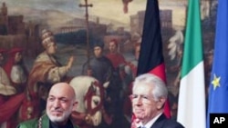 Italian Prime Minister Mario Monti (R) and Afghanistan's President Hamid Karzai shake hands after signing of documents during a meeting at the Chigi Palace in Rome January 26, 2012.