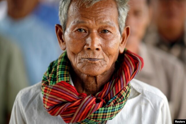 FILE - Sok Teng, 73, waits with other survivors and relatives of victims of the Khmer Rouge regime to enter the Extraordinary Chambers in the Courts of Cambodia (ECCC) to attend the delivery of verdict in the trial of former Khmer Rouge head of state Khieu Samphan and former Khmer Rouge leader ''Brother Number Two'' Nuon Chea on the outskirts of Phnom Penh Aug. 7, 2014.