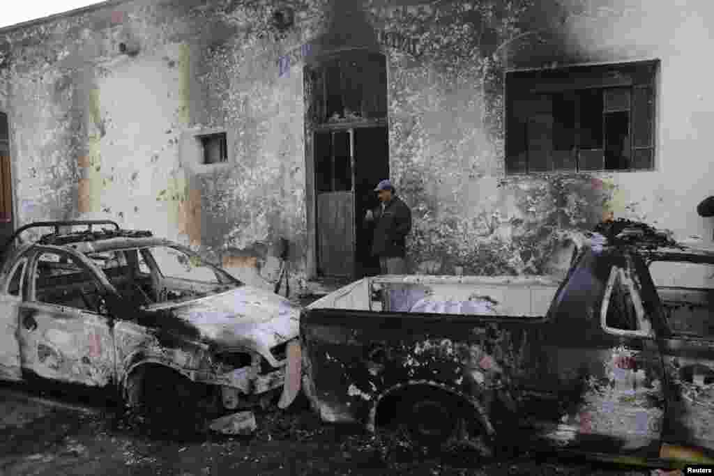 A man stands next to the wreckage of burnt vehicles outside the Guadalupe Victoria town hall in the Mexican state of Puebla. Residents burned the town hall, patrol vehicles and two buildings belonging to Mayor Felipe Cortes, to demand for more security in the area after a local shopkeeper was recently killed by unknown assailants during a robbery, according to local media. 