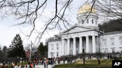 FILE - Gun rights activists and bill supporters wait for the arrival of Vermont Republican Gov. Phil Scott at the Statehouse in Montpelier, VT, Apr. 11, 2018. 