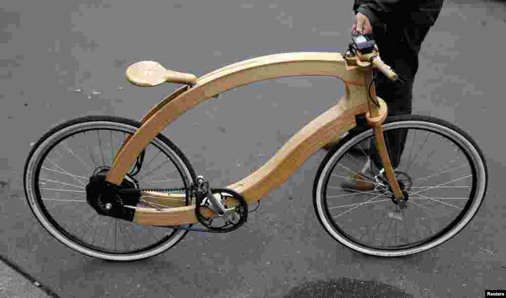 Matthias Broda, inventor and designer of the wooden e-bike, holds a prototype on a street in Berlin. The wooden e-bike produced by German company Aceteam from ash wood, will be launched on the market by spring 2015 and will cost around 3,950 euro ($4,950).