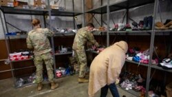 An Afghan refugee looks for donated shoes at the donation center at Fort McCoy U.S. Army base, Sept. 30, 2021, in Ft. McCoy, Wis.