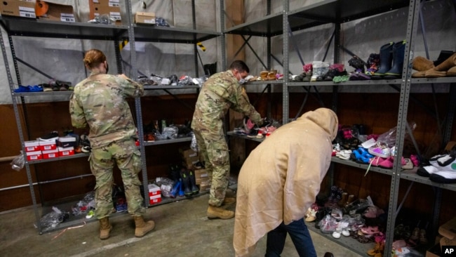 An Afghan refugee looks for donated shoes at the donation center at Fort McCoy U.S. Army base, Sept. 30, 2021, in Ft. McCoy, Wis.