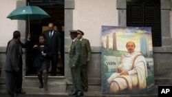 Sudan's President Omar al-Bashir, in doorway, walks past a portrait of late Ethiopian Prime Minister Meles Zenawi, a gift from another delegation, as he arrives to pay his respects to Meles' body lying in state at the national palace in Addis Ababa, Ethio