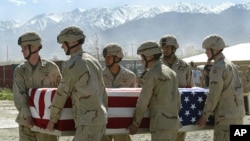 FILE - American soldiers carry the coffin of an American soldier in Afghanistan, April 26, 2003.