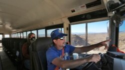 School bus driver by Kelly Maestas travels along a dirt road, with social worker Victoria Dominguez, outside Cuba, N.M., Oct. 19, 2020.