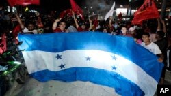 Simpatizantes del Partido LIBRE sostienen una enorme bandera de Honduras después del cierre de las elecciones generales, en San Pedro Sula, Honduras, el 28 de noviembre de 2021. Fotografía tomada el 28 de noviembre de 2021.