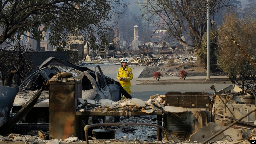 FILE - A California Fire Department forester inspects damage at homes destroyed by fires in Santa Rosa, Calif., Oct. 12, 2017. 